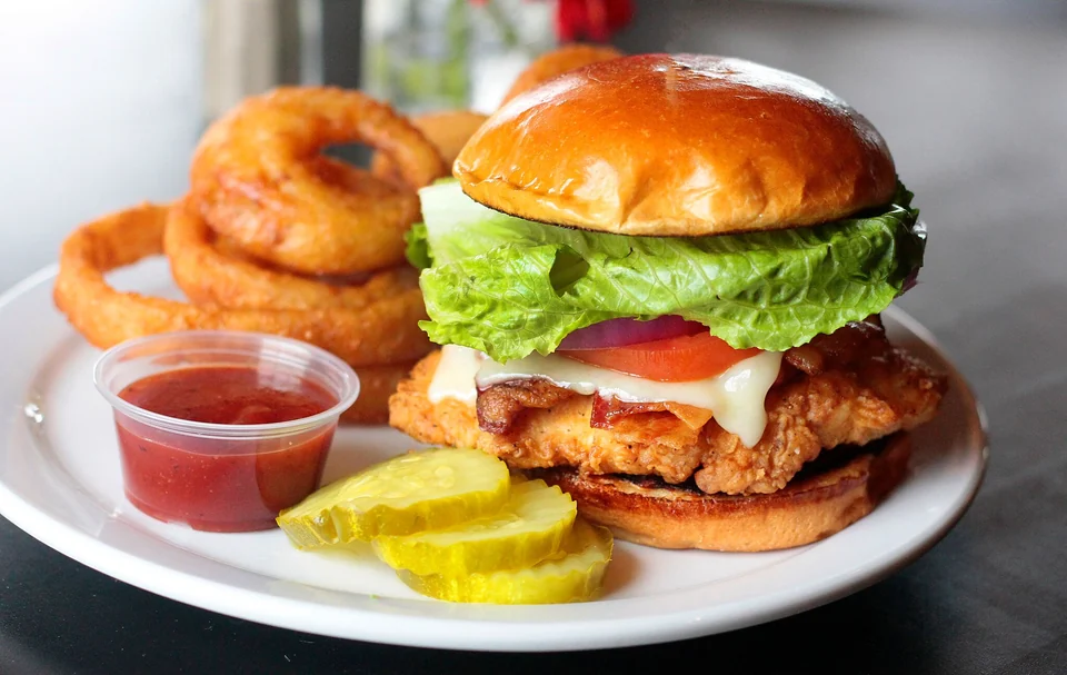 A Garland Mountain chicken sandwich served with onion rings and pickles